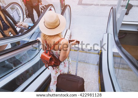 passenger in airport or modern train station, woman commuter travels with luggage