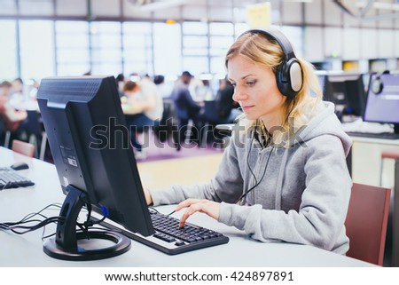 adult education, middle aged woman studying on computer in modern library