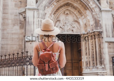 tourist travels in Europe, sightseeing tour, back of woman with backpack looking at historical architecture