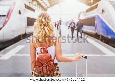 travel by train, woman passenger with suitcase waiting in railway station