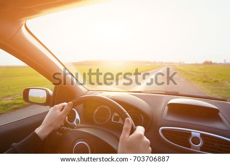 driving car, hands of driver on steering wheel, travel background