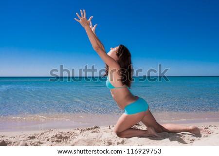 Pretty young woman reaching out to the sun