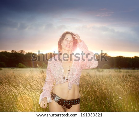 Beautiful Romantic Girl Outdoors in the Field in Sun Light at Sunset. Autumn, Summer. Glow Sun, Sunshine. Backlit. Toned in warm and bright evening colors