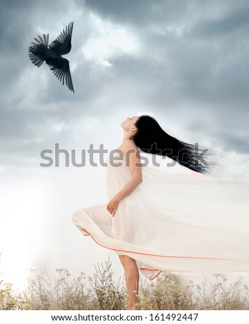 Beautiful young woman waving her hair opposite to flying bird. Freedom concept