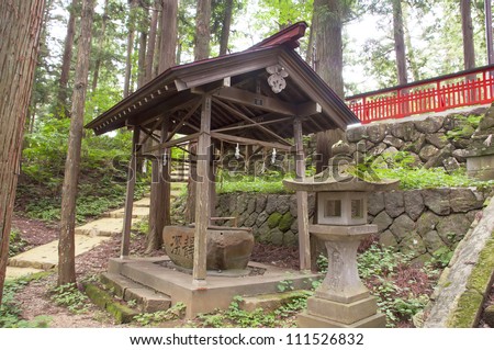 Traditional stone lantern beside a shrine  in a Japanese forest