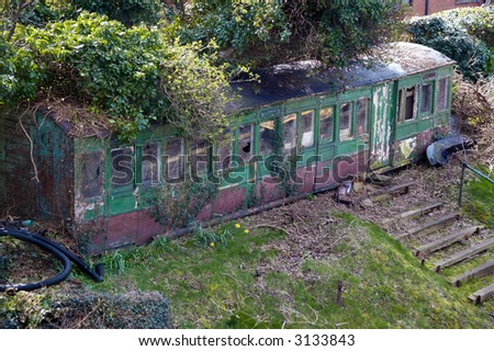 Foliage covers an abandoned train carriage