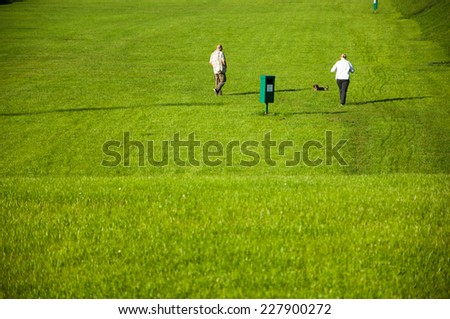 Zagreb, Croatia - October 18, 2014: Two people walking their dog in the park.