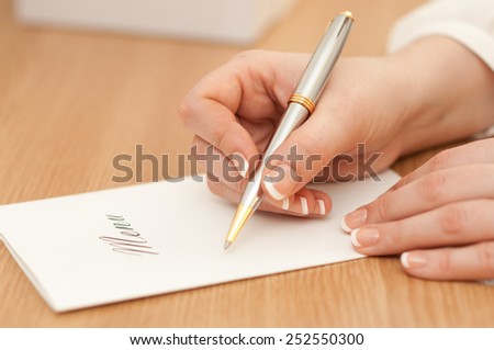 Woman writing on a wedding menu.