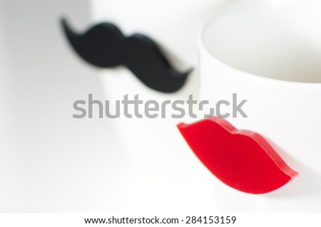 White cups with acrylic lips and moustache.
