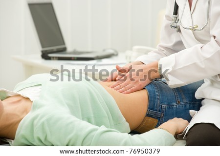 doctor's hands examining female abdomen