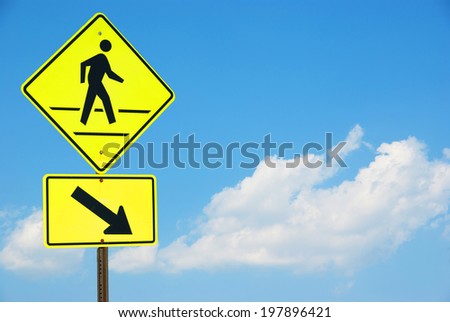Pedestrian sign with a person walking on yellow with a blue sky background