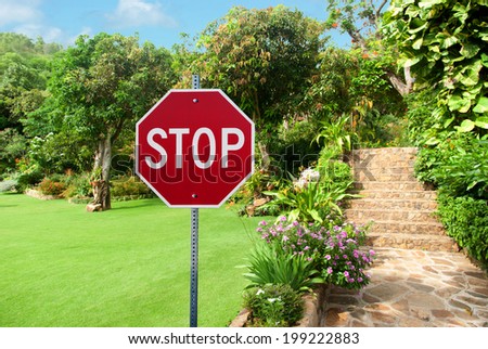 Stop sign against Natural stone landscaping in home garden with stairs during summer time