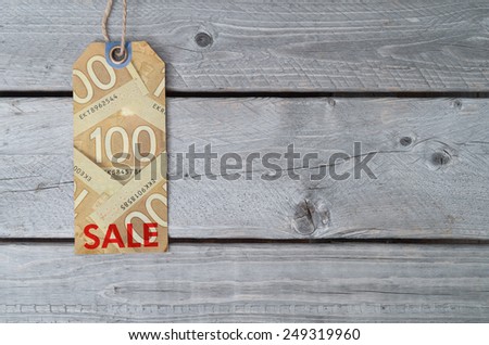 Canadian sale tag on brown vintage paper against wooden background