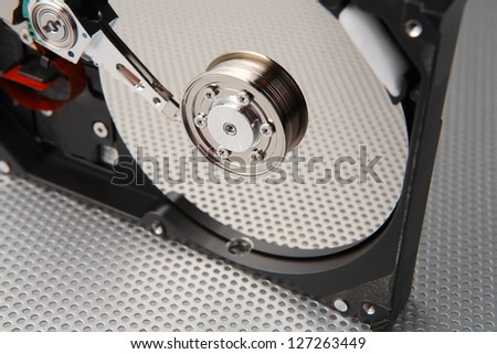 Computer hard disk drive detail with interesting technology background, focused to center of plate