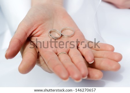 Woman\'s and man\'s wedding hands with the rings, focused to the rings