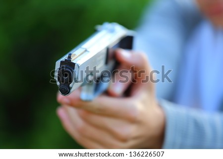 Close up view of someone pointing a gun at the camera