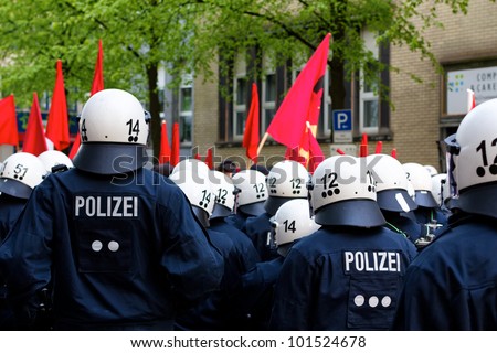 HAMBURG, GERMANY - MAY 1, 2012: Police officers in full riot gear face protesters during the May Day demonstration in Hamburg, Germany, on May 1, 2012.