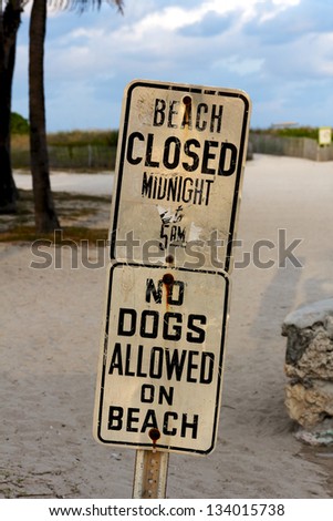 Signs at South Beach, Miami, FL, USA, announcing beach closure times and a ban on dogs.