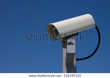 Modern outdoor surveillance camera facing left.
