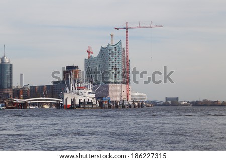 HAMBURG, GERMANY - MARCH 20, 2014: Construction of the landmark Elbe Philharmonic building rises behind the museum freighter Cap San Diego in Hamburg, Germany on March 20, 2014.