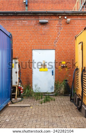 Door with German-language warning labels at an industrial facility.