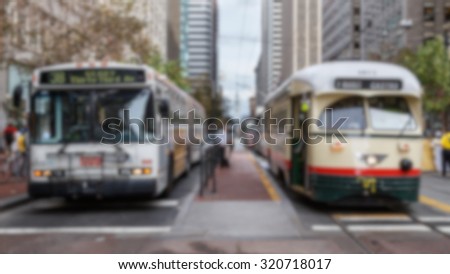 Blurred background of San Francisco public transportation vehicles.