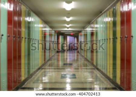 Blurred background of tunnel-like hallway lined with multi-colored lockers.