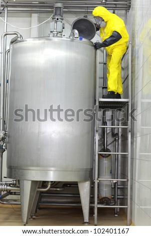 Fully protected engineer in uniform,mask,gloves,boots 	technician controlling industrial process in factory