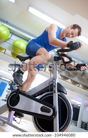 Cycling fit man on bike in gym