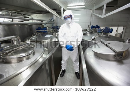 biotechnology specialist in protective uniform,mask,goggles,gloves and wellies in laboratory