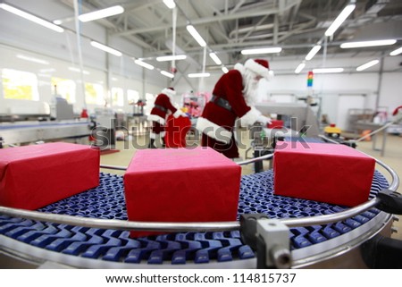 Two Santa Clauses working in Xmas Gifts Factory