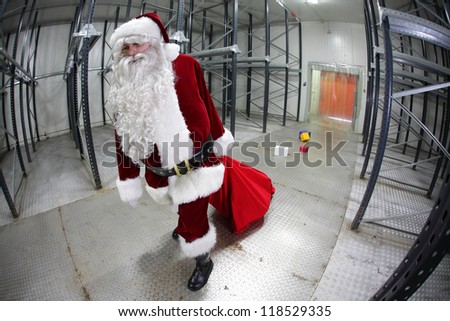 The last,tired Santa Claus loosing gifts from red sack leaving empty storehouse