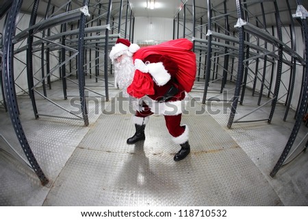 Santa Claus with red sack in empty storehouse - fish eye photo