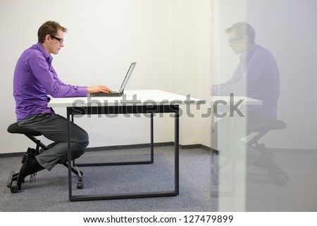 bad sitting posture at workstation. man on kneeling chair