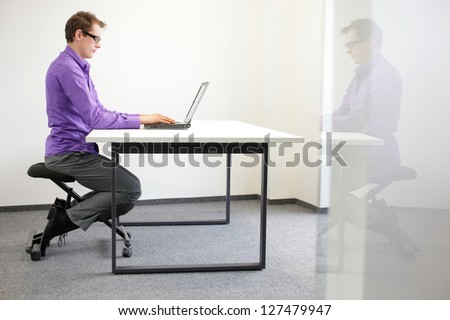 correct sitting position at workstation. man on kneeling chair