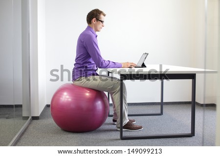 Man On Stability Ball Working With Tablet - Correct Sitting Position At Workstation