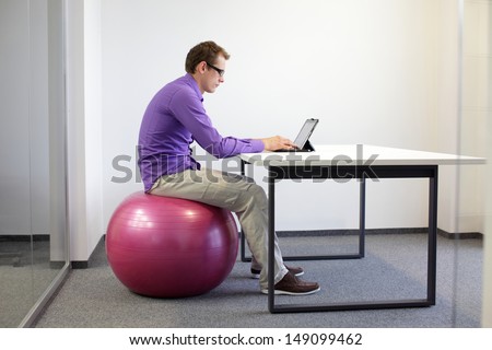 Bad Sitting Posture At Tablet - Business Man On Stability Ball In His Office