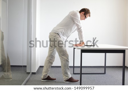 wrists exercise durring office work - standing man reading at tablet in his office