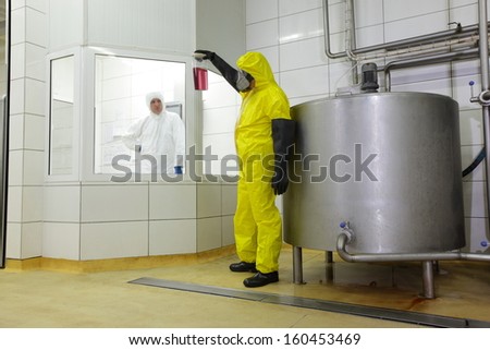 two technicians in protective uniforms working in industrial environment
