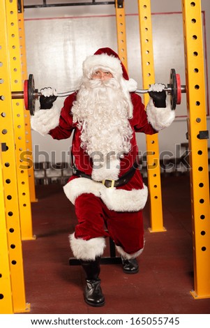 Santa Claus lifting weights in gym - physical condition training before Christmas