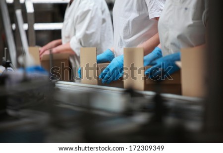 People Working On Packing Line In Factory