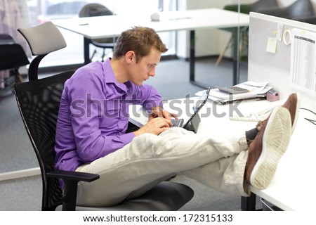 Young businessman caucasian in his office  working with tablet - bad sitting posture