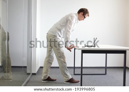 wrists exercise during office work - standing man reading at tablet in his office