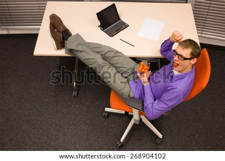 man eating raw food - tomatoes - in his office