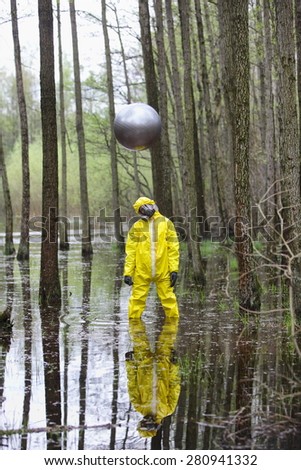 professional in protective uniform, mask, gloves with silver sphere drone above his head   in contaminated  floods area