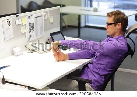 man office worker,exercising during work with tablet in his office