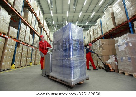 Warehousing - Two workers in uniforms working in storehouse