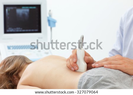 Child\'s lower back diagnosis carried out with the use of an ultrasound