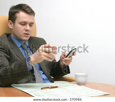 businessman with phone is reading business card