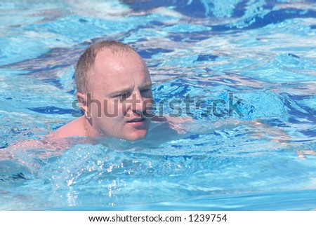 man swimming in cristal water swimming-pool